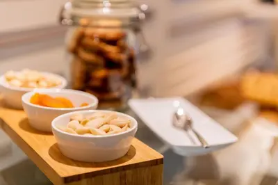 a wooden tray with three bowls of nuts and fruit at Atenea Rekord Suites Barcelona in Barcelona