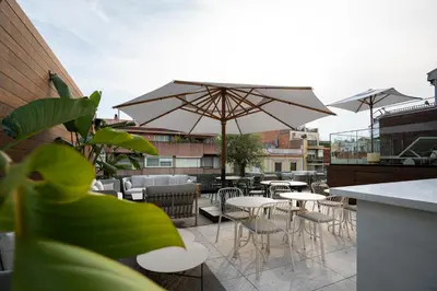 a patio with tables and chairs and an umbrella at Zenit Borrell in Barcelona
