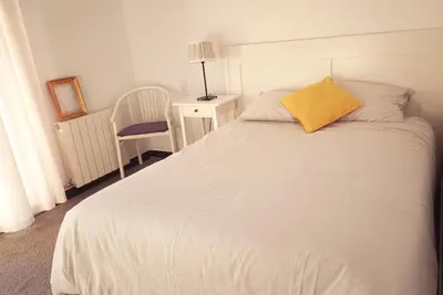 a bedroom with a white bed with a yellow pillow at Habitación doble con Balcón - Casa rural compartida - Coliving in Torrellas de Foix