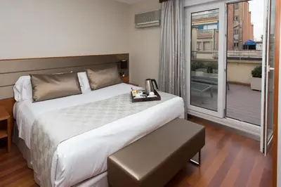 a bedroom with a large bed and a large window at Catalonia Diagonal Centro in Barcelona