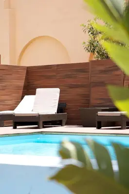 a pool with a bed and a lounge chair at Catalonia Portal de l'Angel in Barcelona