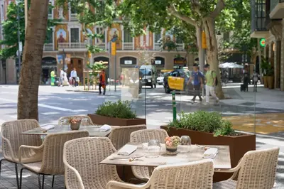 a person holding a tray of food on a table at Catalonia Eixample 1864 in Barcelona