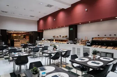 a restaurant with tables and chairs and a counter at Catalonia Sagrada Familia in Barcelona