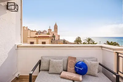 a couch on a balcony with a view of the ocean at Sitges Group Ocean in Sitges