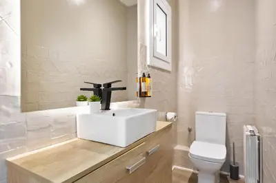 a bathroom with a white sink and a toilet at Sitges Group Ocean in Sitges