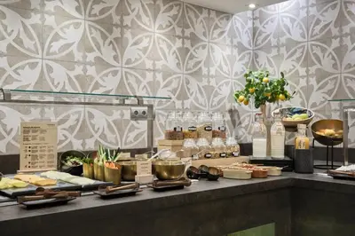 a buffet of food on a counter in a restaurant at Catalonia Park Güell in Barcelona