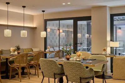 a dining room with tables and chairs and windows at Catalonia Mikado in Barcelona