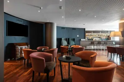 a restaurant with chairs and tables and a bar at Catalonia Park Putxet in Barcelona