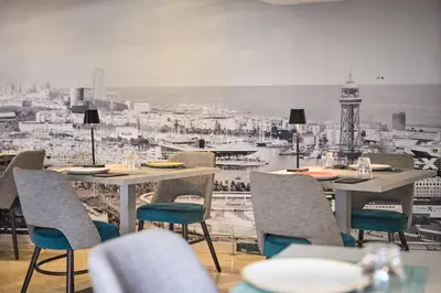 a restaurant with tables and chairs and a view of a city at Catalonia Atenas in Barcelona