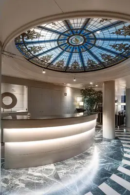 a lobby with a stained glass ceiling and a counter at Catalonia Roma in Barcelona