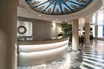 a lobby with a glass ceiling and a bar at Catalonia Roma in Barcelona