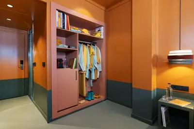 a walk in closet with orange and green walls at chic&basic Reding in Barcelona