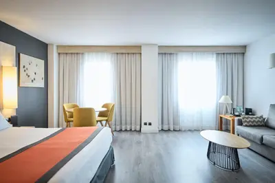 a hotel room with a bed and a couch at Catalonia Sabadell in Sabadell