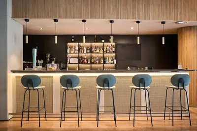a bar with three blue stools at a counter at Catalonia Sabadell in Sabadell