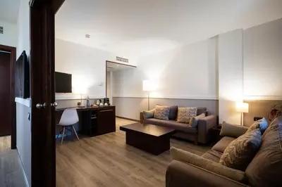 a living room with a couch and a desk at Catalonia Gran Hotel Verdi in Sabadell