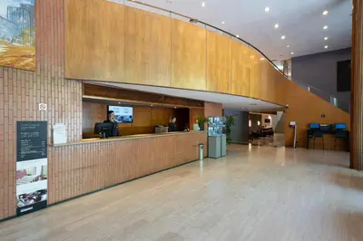 a lobby of a building with a reception counter at Catalonia Gran Hotel Verdi in Sabadell