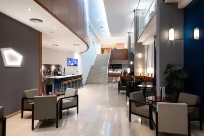 a restaurant with tables and chairs and a staircase at Catalonia Gran Hotel Verdi in Sabadell