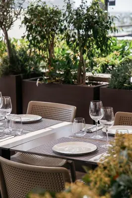 a table with glasses and plates on top at Duquesa de Cardona Hotel 4 Sup by Grup Duquessa in Barcelona