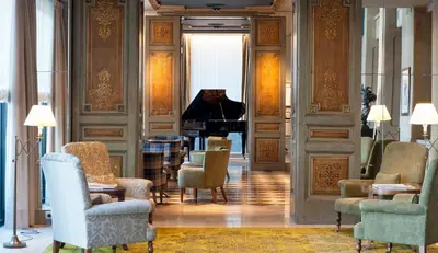 a living room with chairs and a piano at Duquesa de Cardona Hotel 4 Sup by Grup Duquessa in Barcelona