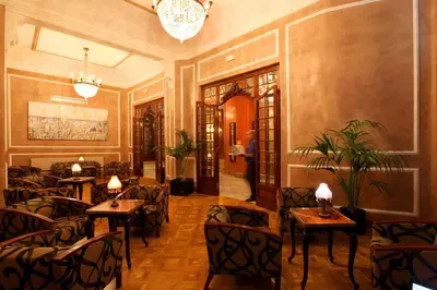 a restaurant with chairs and tables and a chandelier at Hotel Nouvel in Barcelona