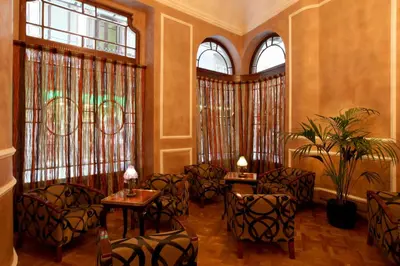 a room with chairs and tables and windows at Hotel Nouvel in Barcelona