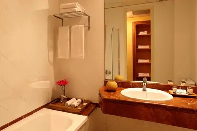 a bathroom with a sink and a mirror and a tub at Hotel Nouvel in Barcelona