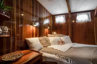 a bed in a room with wooden walls and a table at SPACIOUS YACHT HOTEL BARCELONA CITY CENTER 5 CABINs in Barcelona