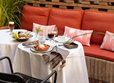 a table with two plates of food and glasses of wine at Alexandra Barcelona Hotel, Curio Collection by Hilton in Barcelona