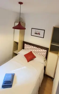 a bedroom with a bed with a red pillow on it at Lovely Appart & Sky View SAGRADA FAMILIA in Barcelona