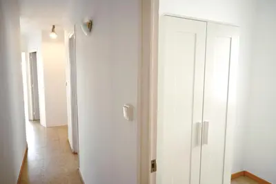a hallway with white walls and a white door at Homenfun Barcelona Park Güell in Barcelona