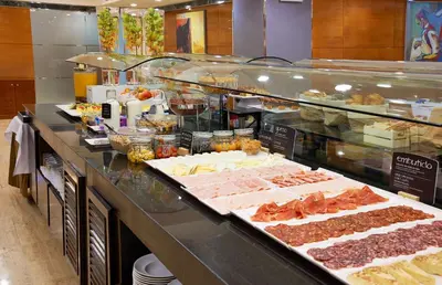 a buffet line with many different types of food at NH Barcelona Eixample in Barcelona