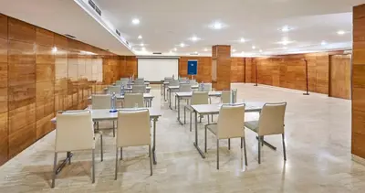 a row of tables and chairs in a room at NH Barcelona Eixample in Barcelona