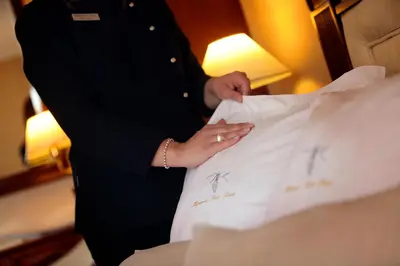 a man in a suit standing next to a bed at Apartaments-Hotel Hispanos 7 Suiza in Barcelona