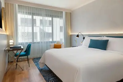 a bedroom with a large white bed and a window at Renaissance Barcelona Hotel in Barcelona