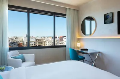 a hotel room with a bed and a desk and window at Renaissance Barcelona Hotel in Barcelona