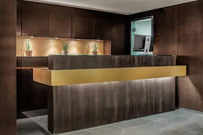 a lobby with a reception desk with potted plants at AC Hotel Irla by Marriott in Barcelona
