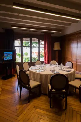 a conference room with a table and chairs and a television at Hotel Subur Maritim in Sitges