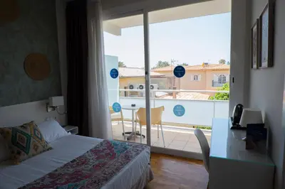 a bedroom with a bed and a view of a balcony at Hotel Subur Maritim in Sitges