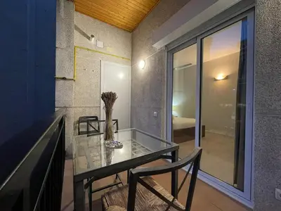 a glass table and chairs in a room with a window at BarcelonaForRent Urban Town Suites in Barcelona