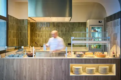 a man walking past a counter in a kitchen at Catalonia La Maquinista in Barcelona