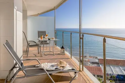a balcony with a table and chairs and the ocean at Calipolis in Sitges