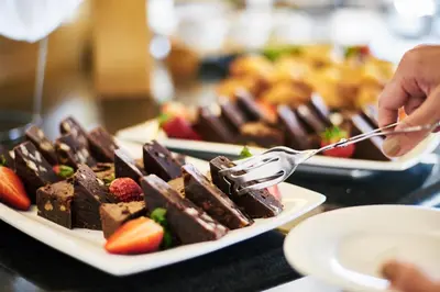 a person eating chocolate desserts on plates on a table at Calipolis in Sitges