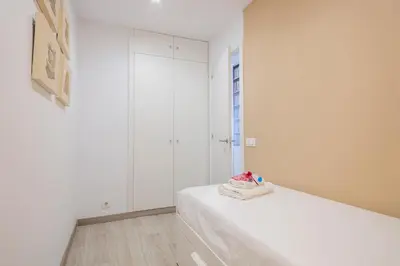 a white room with a bed with white cabinets at Alcam Books in Barcelona