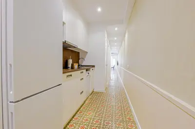 a hallway with a kitchen with a rug on the floor at Alcam Books in Barcelona