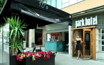 a woman is standing outside of a restaurant at Park Hotel in Barcelona
