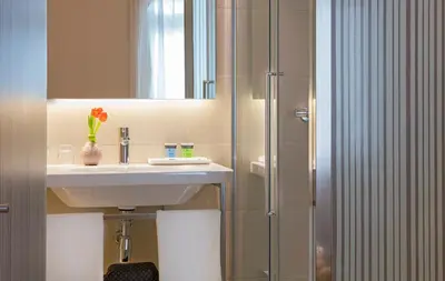 a bathroom with a sink and a shower with a mirror at Park Hotel in Barcelona
