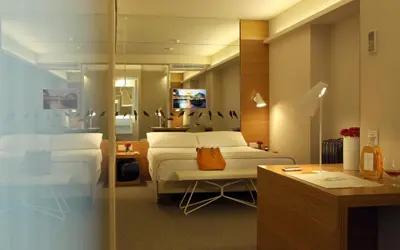 a bedroom with two beds and a desk and a mirror at Park Hotel in Barcelona