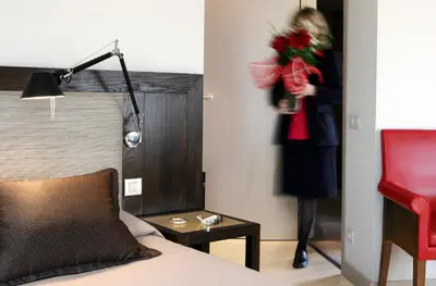 a woman holding a bouquet of flowers in a hotel room at Park Hotel in Barcelona