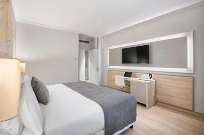 a hotel room with a bed and a flat screen tv at Salles Ciutat del Prat Barcelona Airport in El Prat de Llobregat