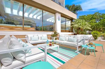 a patio with white couches and a table at Sumus Hotel Stella and Spa 4S Adults Recommended in Pineda de Mar
